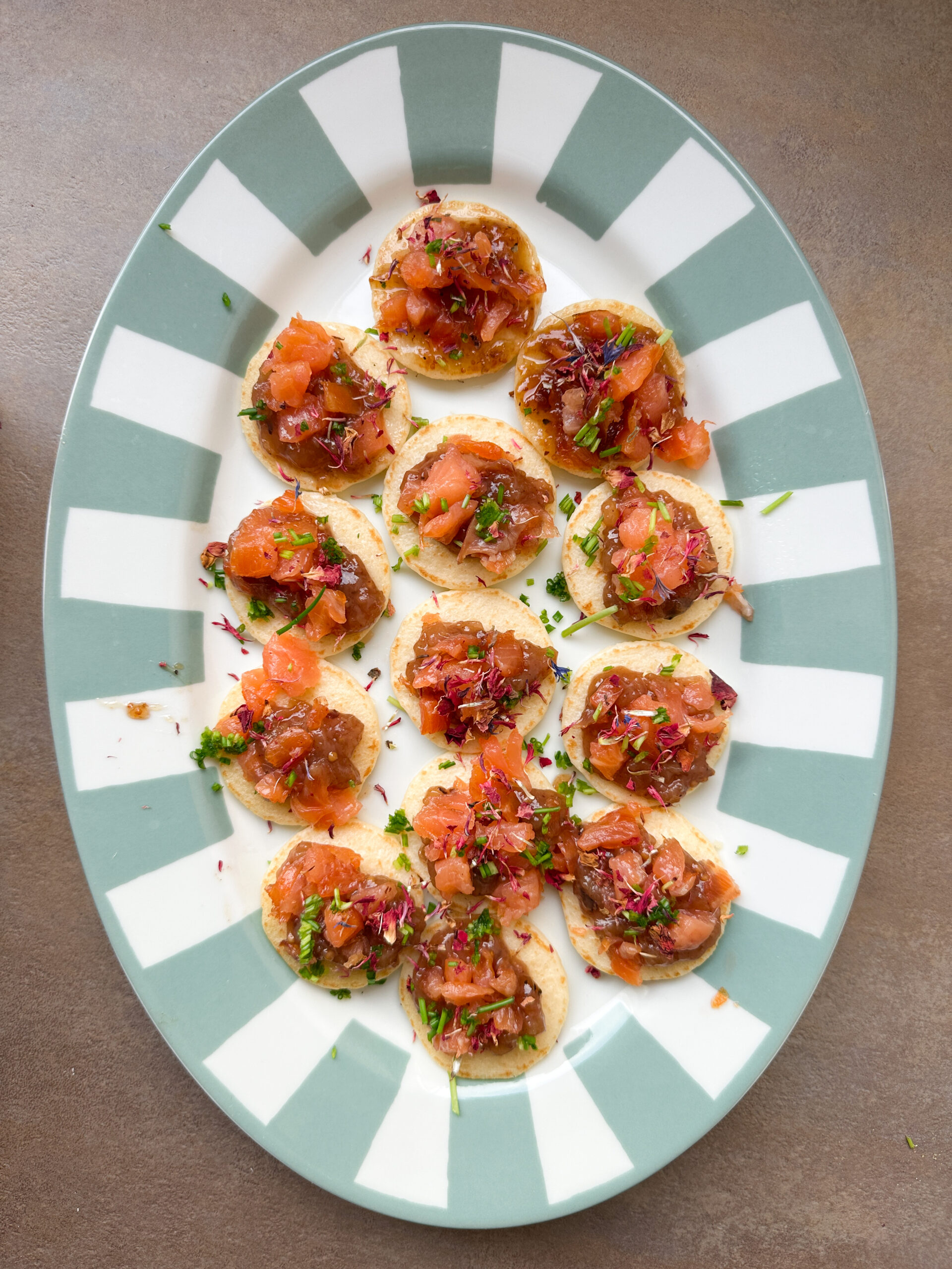 Bites met zalm op een gestreepte schaal
